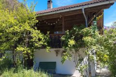 Seitenansicht vom Ferienhaus Schwanderbärgli mit grüner Sitzbank