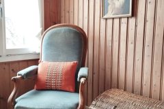 Antiker Sessel neben Korbtruhe und Ankerbild