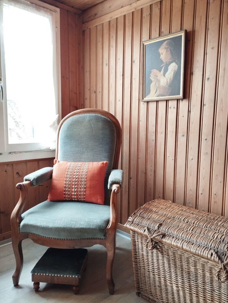 Antiker Sessel mit Bild und Truhe im Ferienhaus Schwanderbärgli