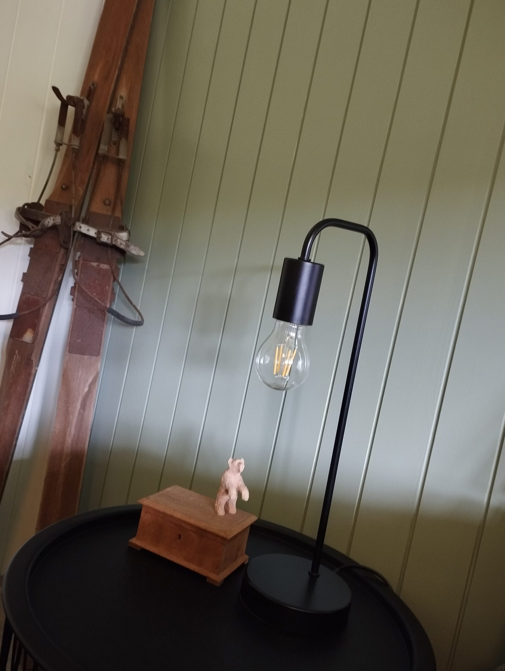 Nachttischlampe mit alten Skiern im Hintergrund