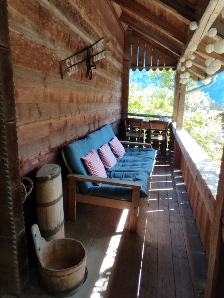 Laube mit Sofa und antiker Deko im Ferienhaus Schwanderbärgli