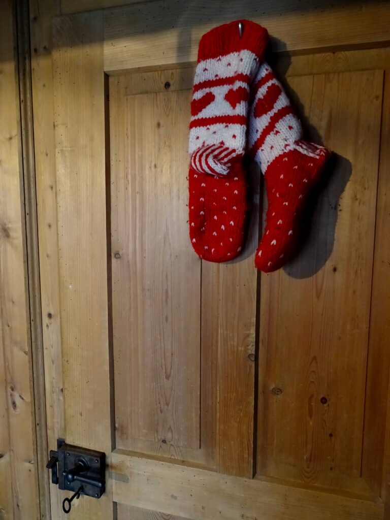 Gestrickte Socken aufgehängt an einer Holztüre